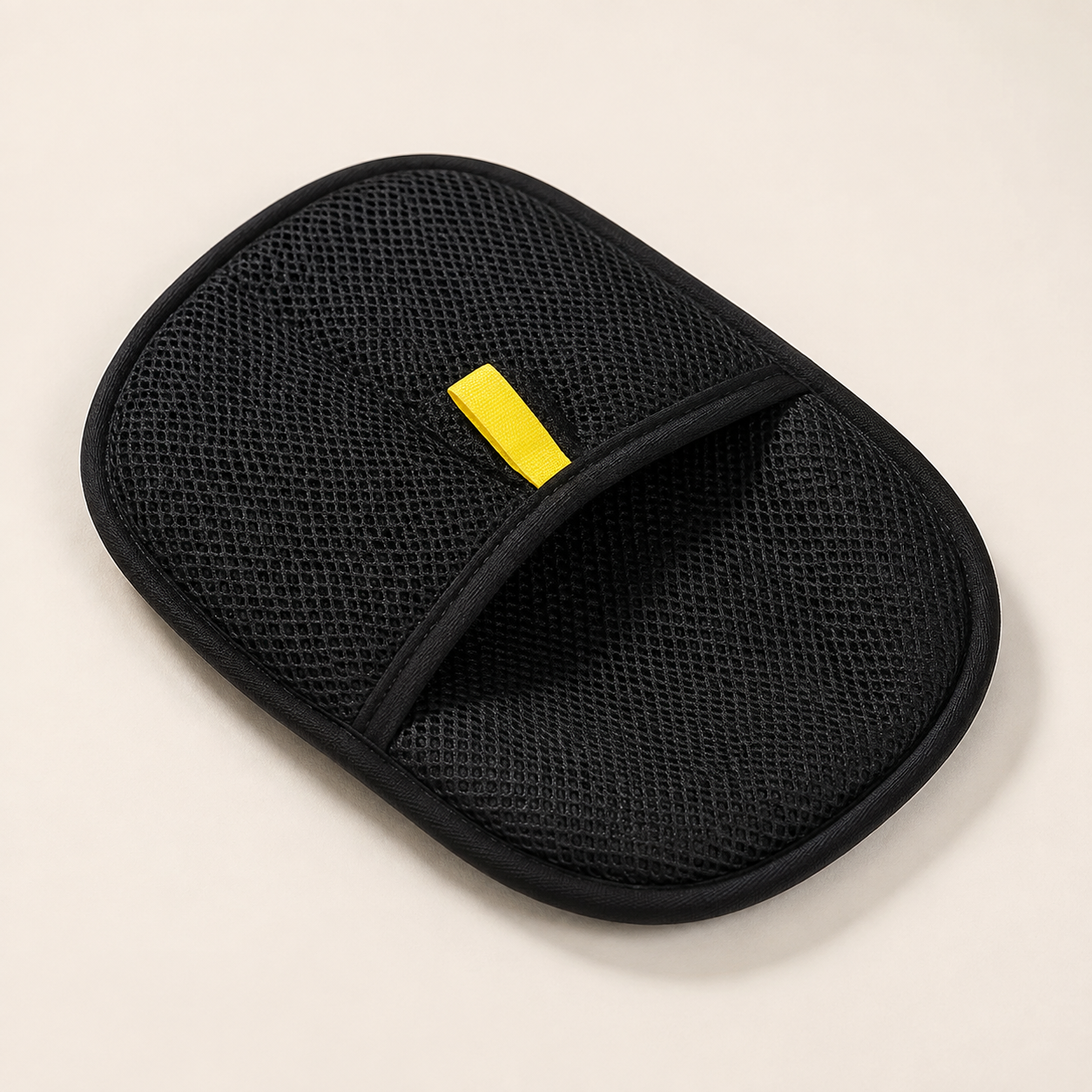 Black pet grooming mitt in clean studio setting